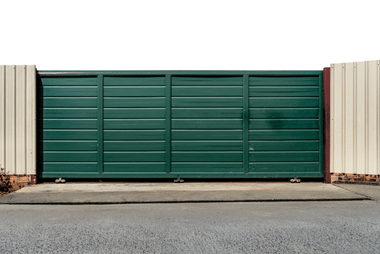Sliding gate installed along a driveway on uneven ground