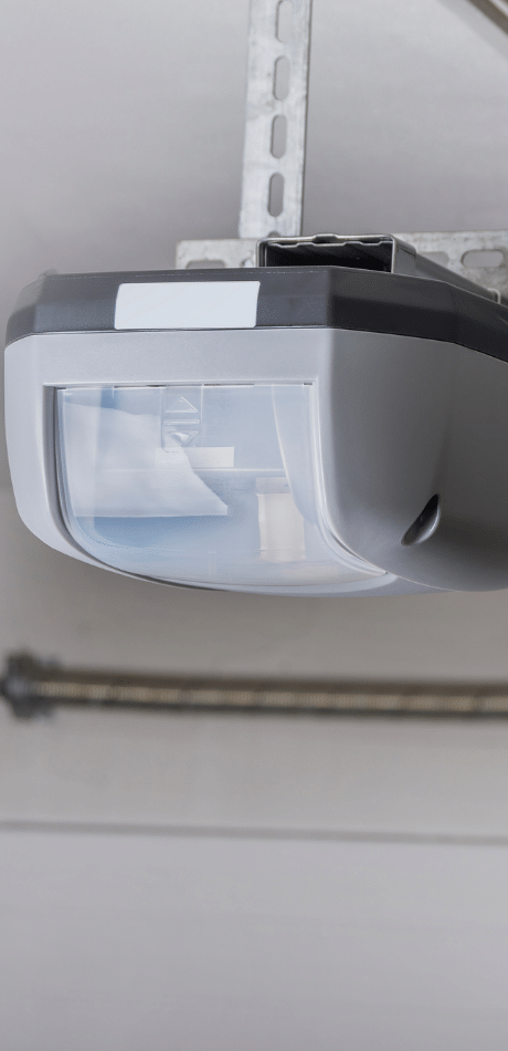 Close-up of a garage door opener motor unit with safety sensor light