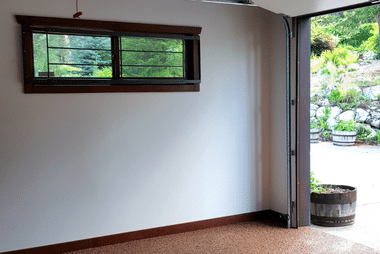 Sectional panel lift garage door with panels stacked along the ceiling