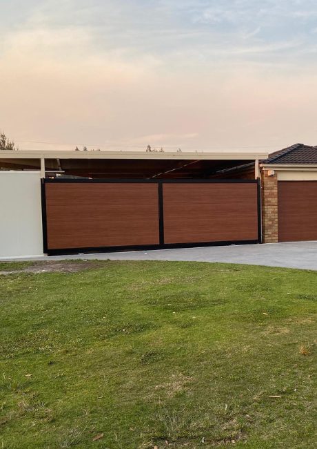 Custom timber-look sliding gate matching a garage door on a residential driveway.