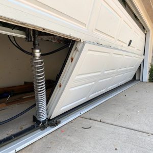 Damaged sectional garage door panel showing dents that need professional repair