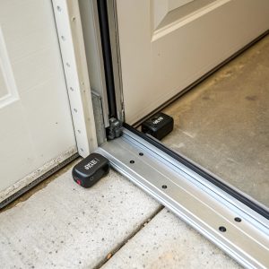 Garage door safety sensors showing photo-eye beam alignment for automatic reverse protection